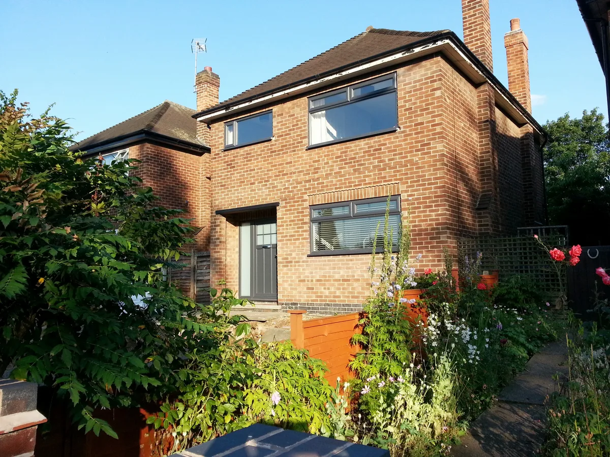Dark sliding doors on a garden-facing brick house